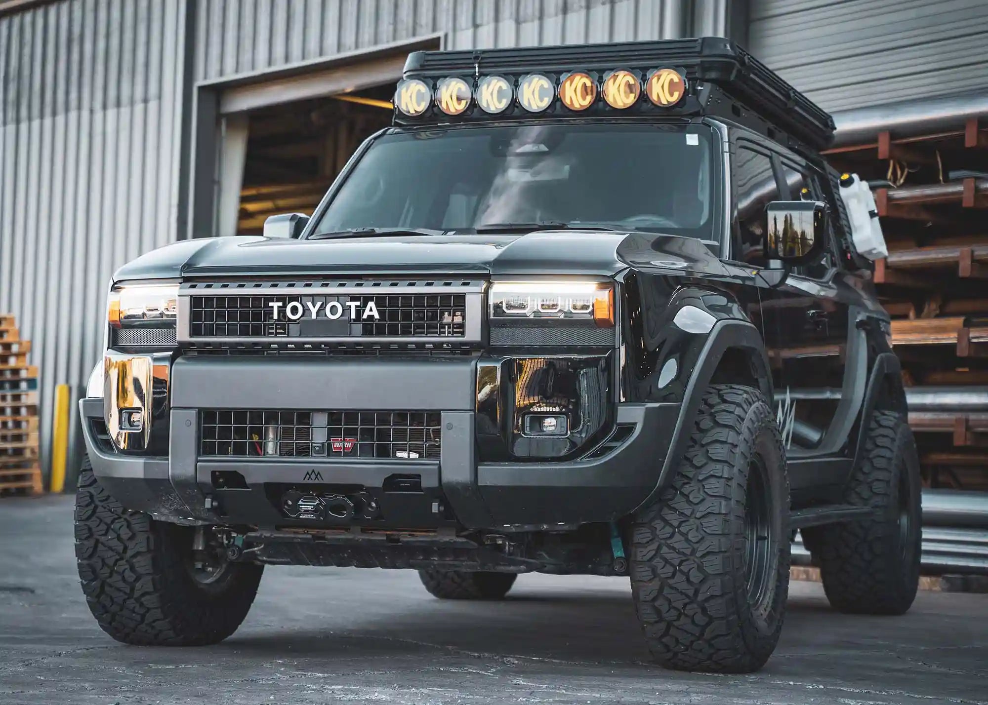 Black 2025 Land Cruiser 250 with LC250 Front Bumper from Backwoods Adventure Mods installed for off roading.