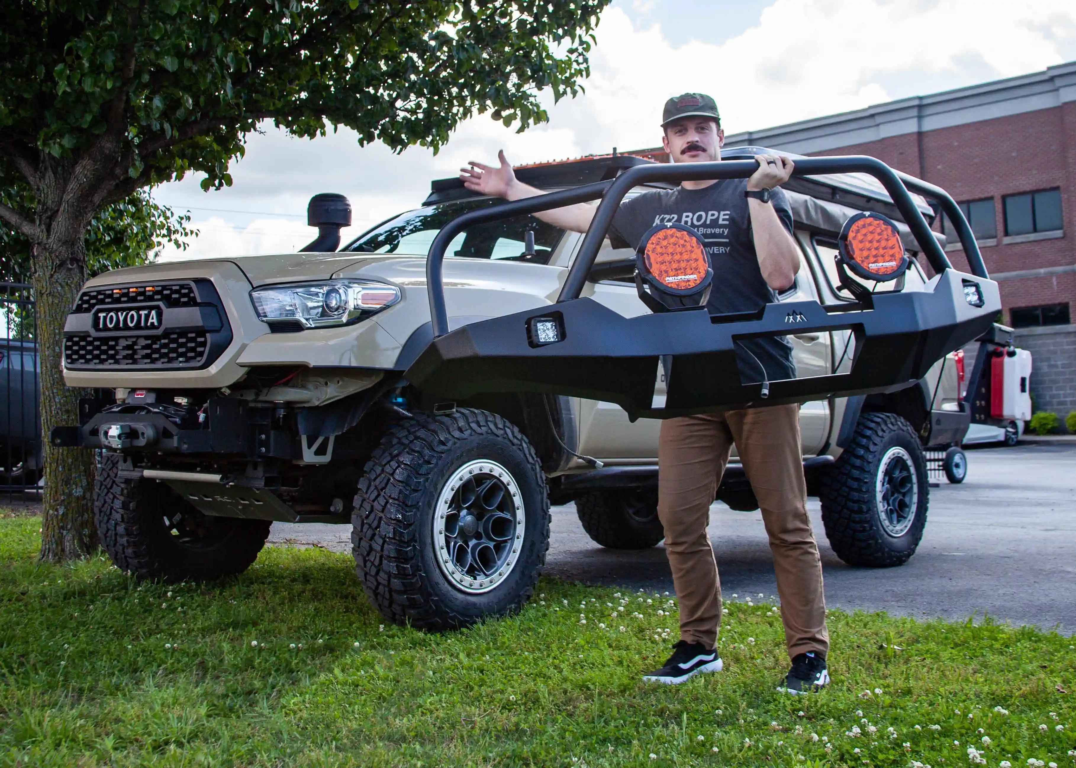 Man holding the Backwoods Adventure Mods Hi-Lite Overland Tacoma Front Bumper with Bull Bar with one hand
