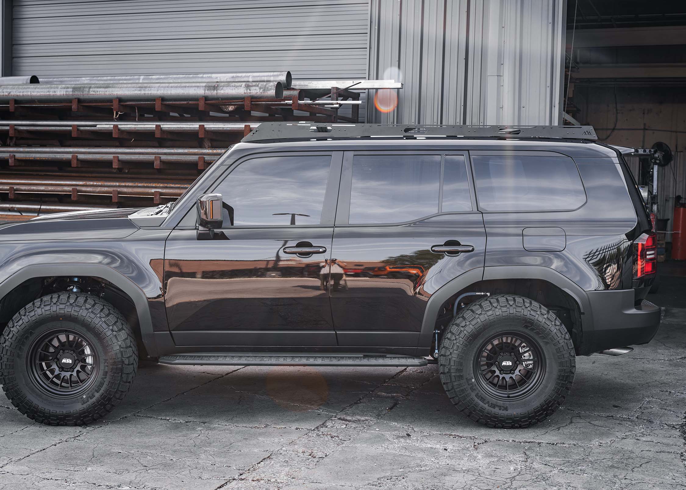 Driver-side of a Toyota Land Cruiser 250 with a Backwoods Adventure Mods DRIFTR roof rack installed