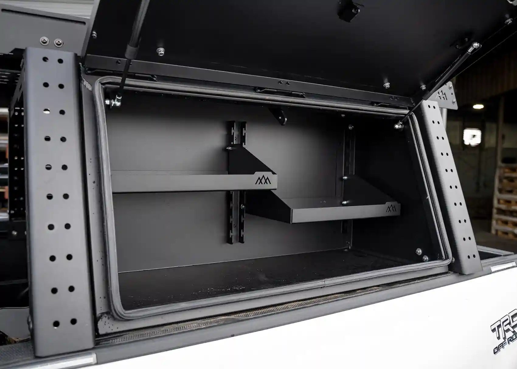 Adjustable shelving inside the Backwoods Adventure Mods Toyota Tacoma bed rack storage box