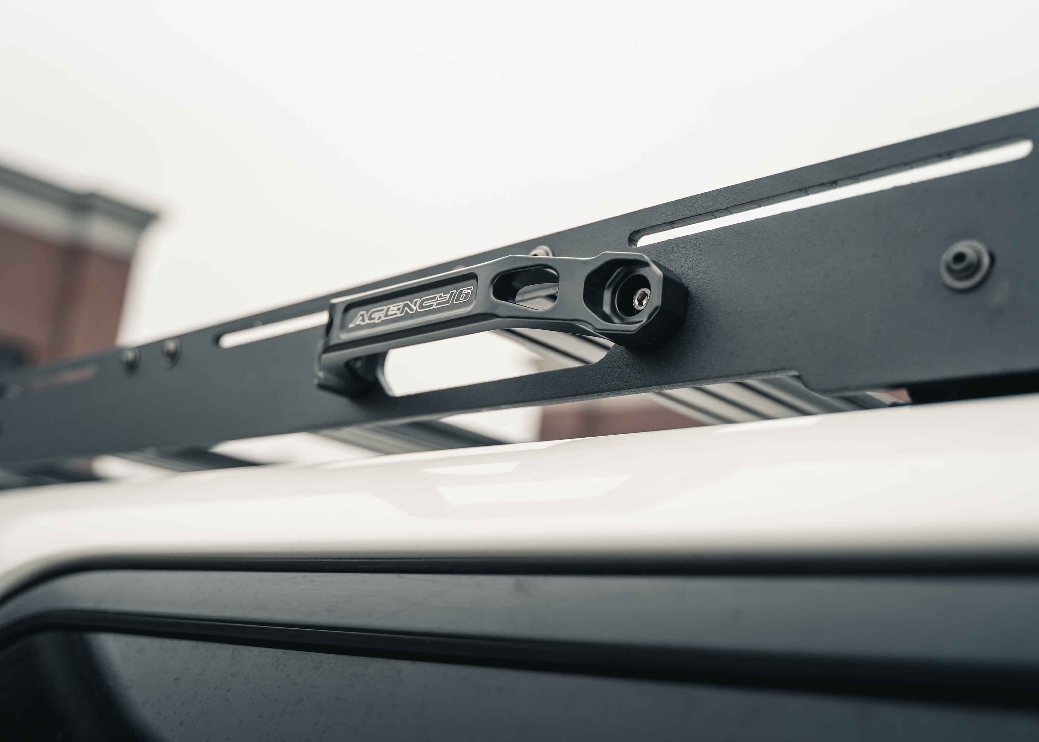 Close up of Agency 6 Grab Handle mounted to the side of the Backwoods Adventure Mods Toyota 2010-2024 5th Gen 4Runner DRIFTR Roof Rack to easily reach cargo and gear stored on top of the roof rack