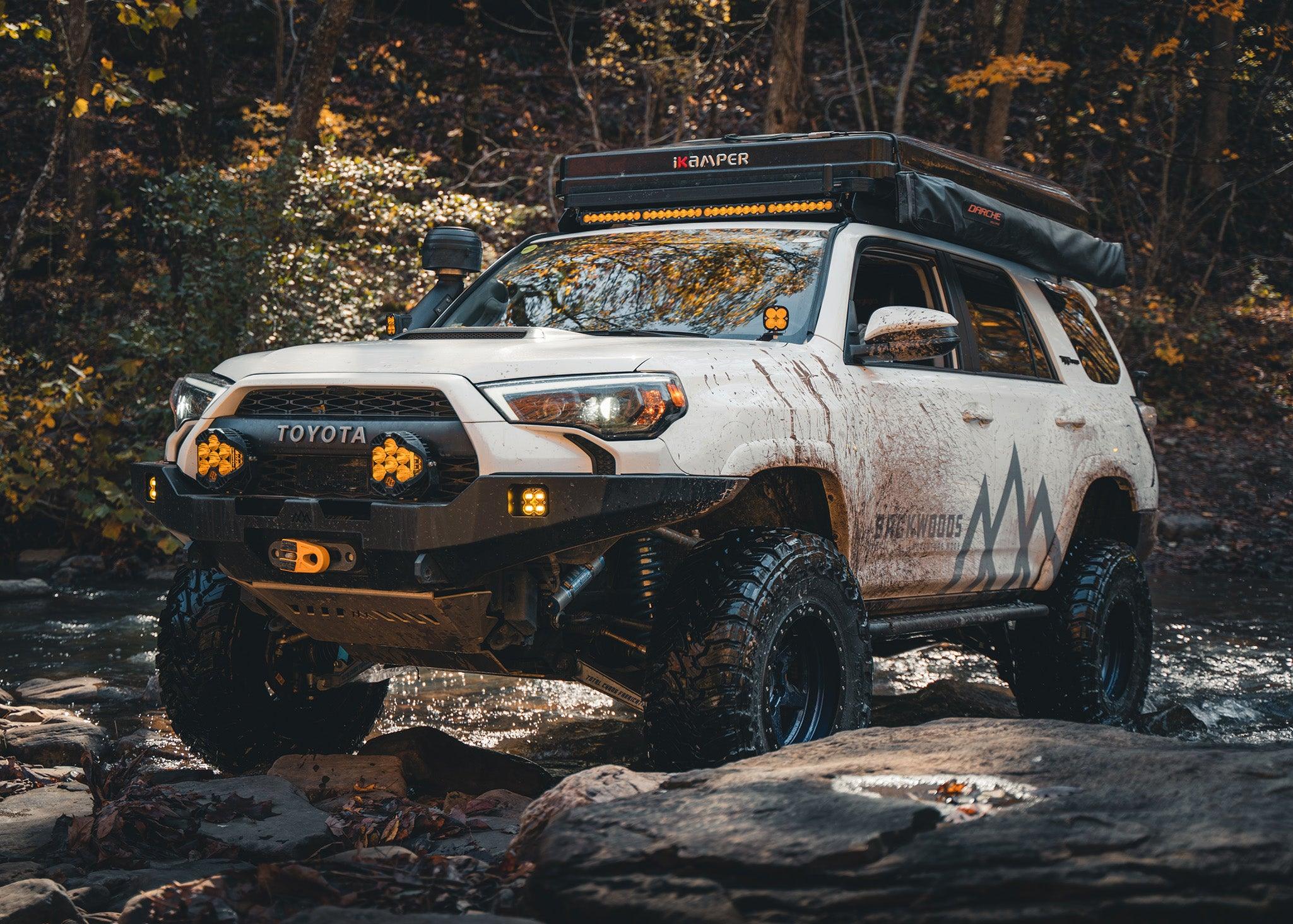 Man driving off road with the Backwoods Adventure Mods 2014-2022 5th Gen Toyota 4Runner Hi-Lite Overland Front Winch Bumper installed
