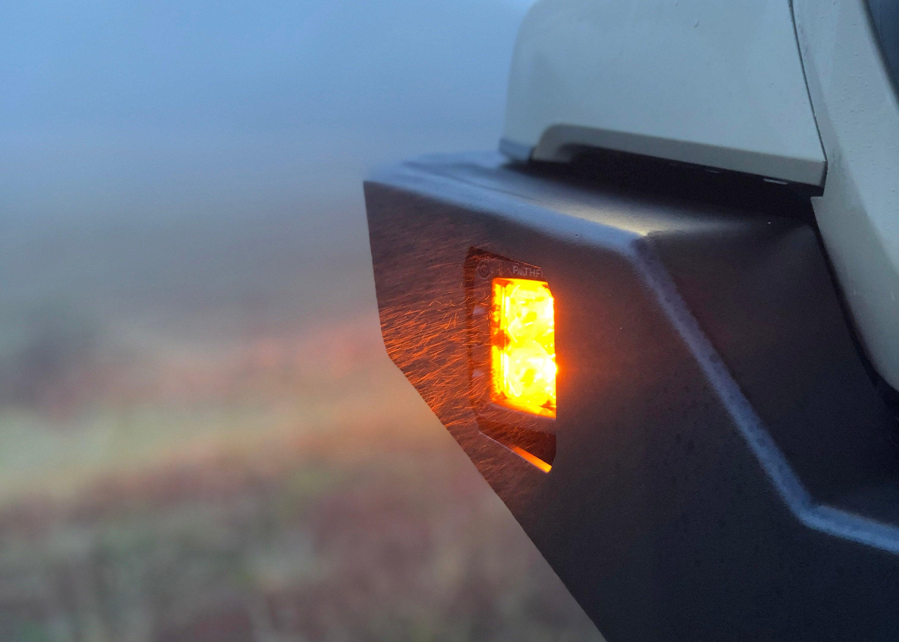 Pathfinder 2 inch Surface Mount Amber LED light pod installed in a Backwoods Adventure Mods Hi-Lite series hybrid Toyota Tacoma high clearance bumper