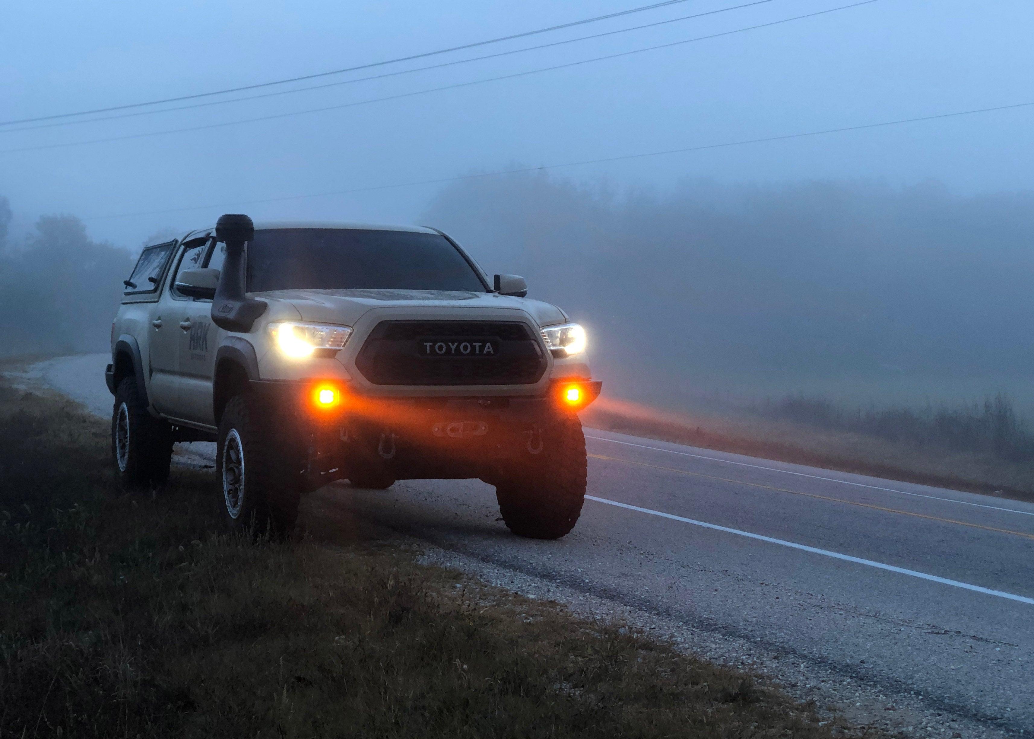 Pathfinder 2 inch Surface Mount Amber LED light pods with spot pattern installed in a Backwoods Adventure Mods Hi-Lite series hybrid Toyota Tacoma off road bumper